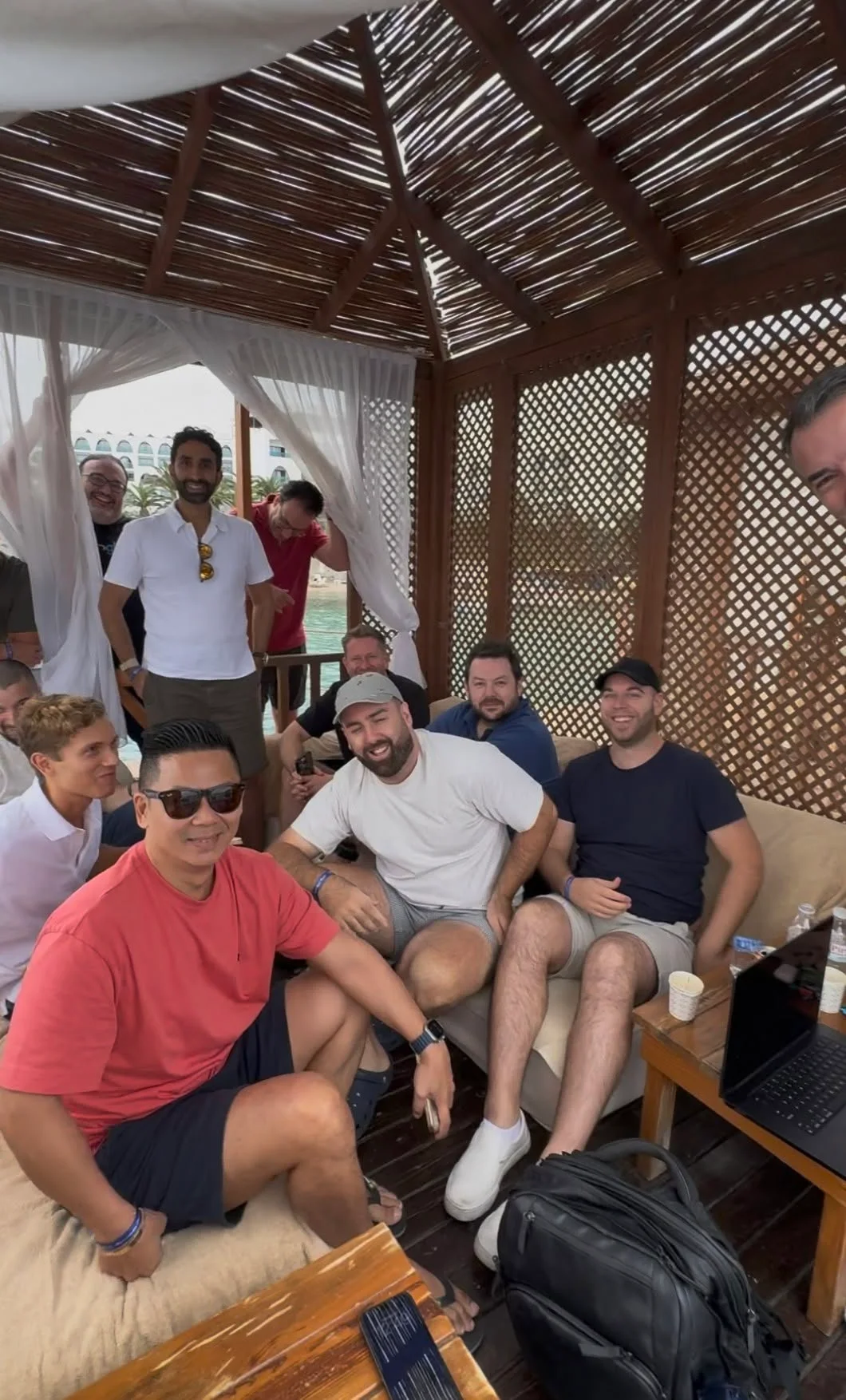 Mastermind attendees gathered for an informal conversation in a shaded cabana