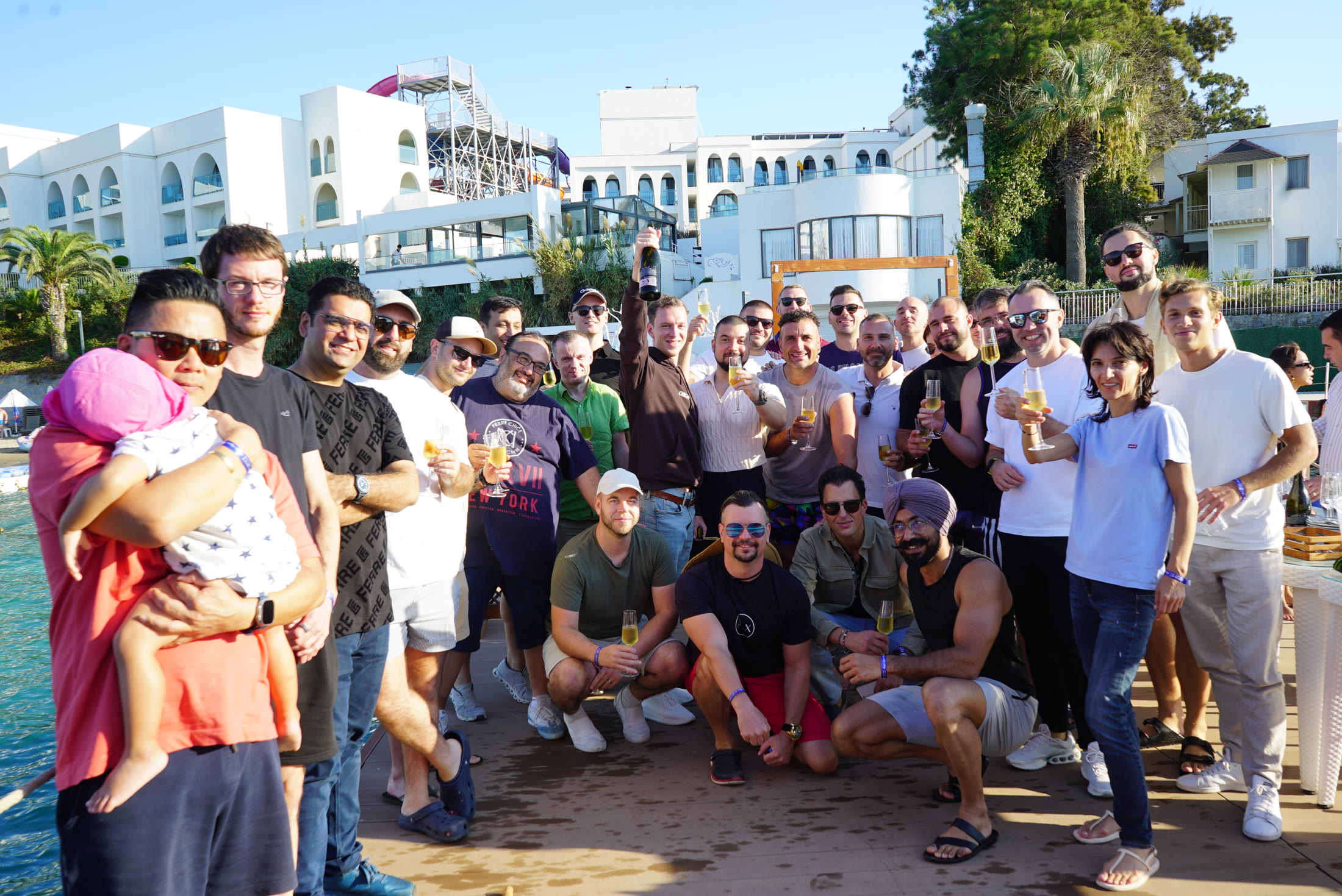 Holistic SEO Mastermind attendees raising a toast together beside the water in Kuşadası