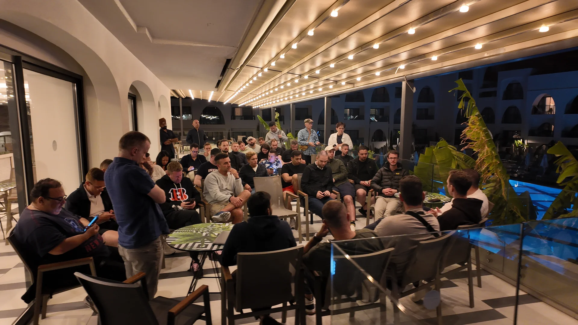 Attendees gathered in a circle for an evening Q&A on the illuminated hotel terrace