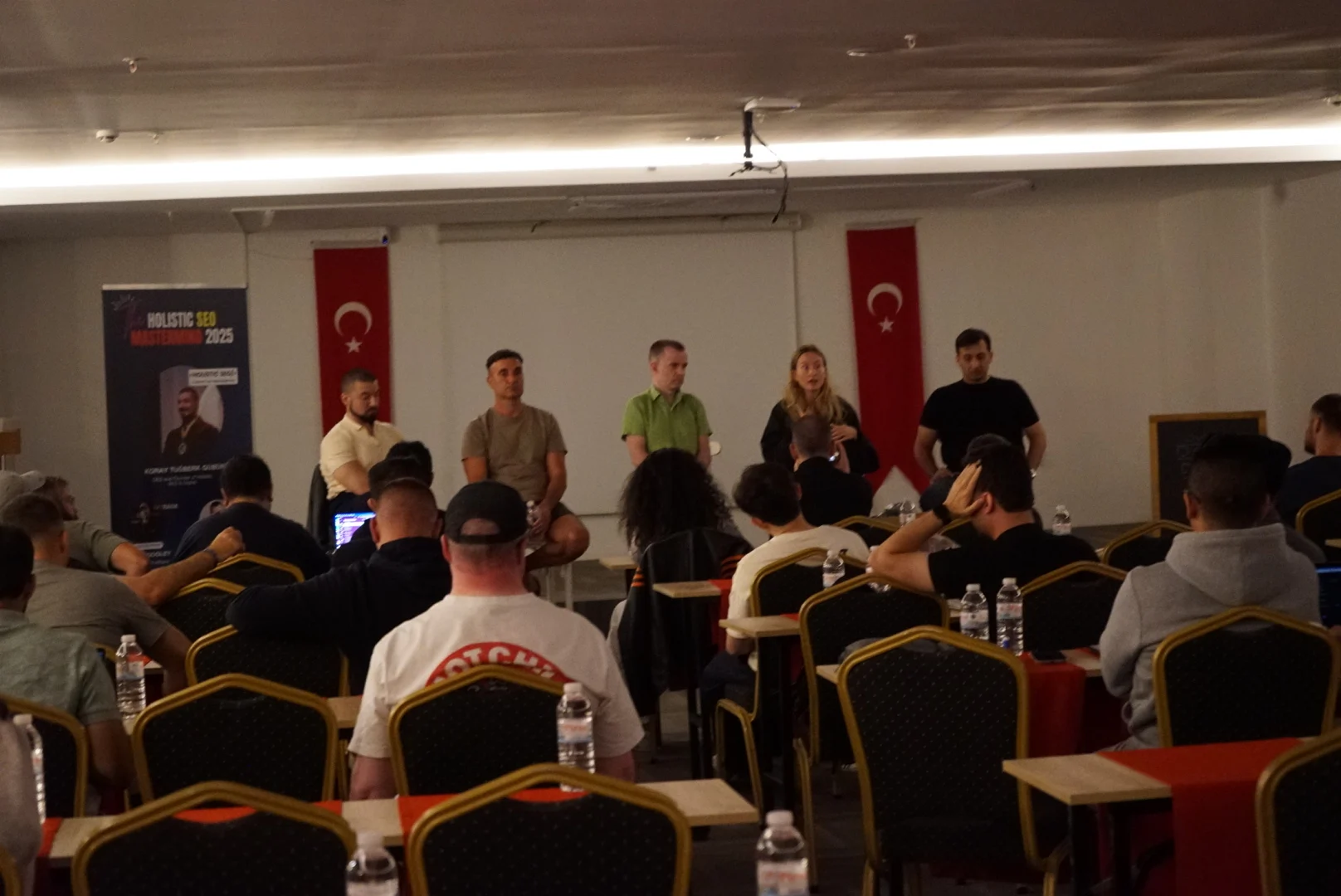 Panel members discussing questions in front of the seated mastermind audience
