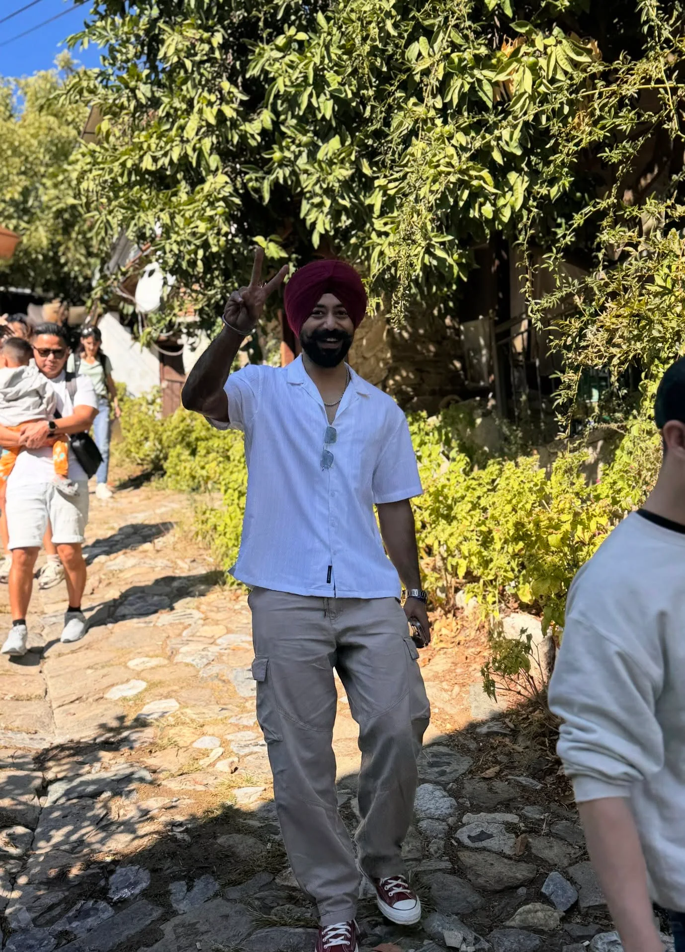 An attendee smiling during a group walk along a leafy stone path